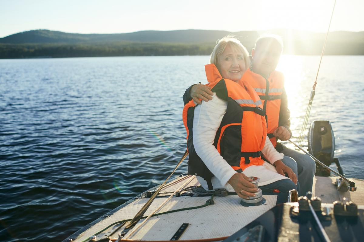 Couple traveling on boat safely wearing a life vest